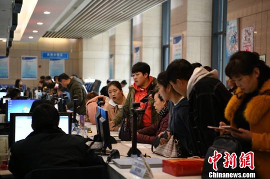 圖為民眾正在蘭州新區(qū)政務(wù)大廳咨詢辦理事項(xiàng)。　黃帆 攝